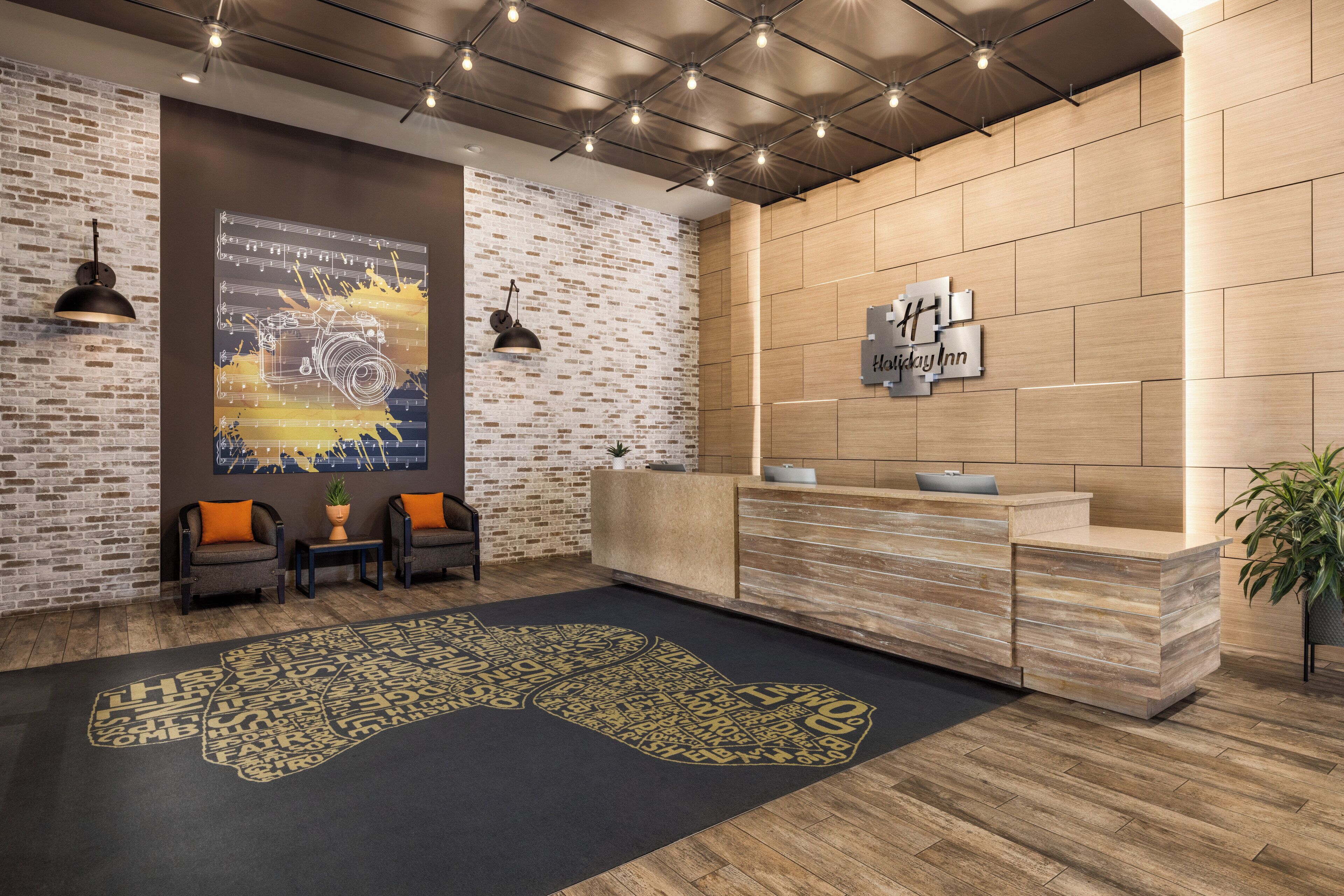 A reception area with a brick wall, a wooden reception desk, and a large poster on the wall.