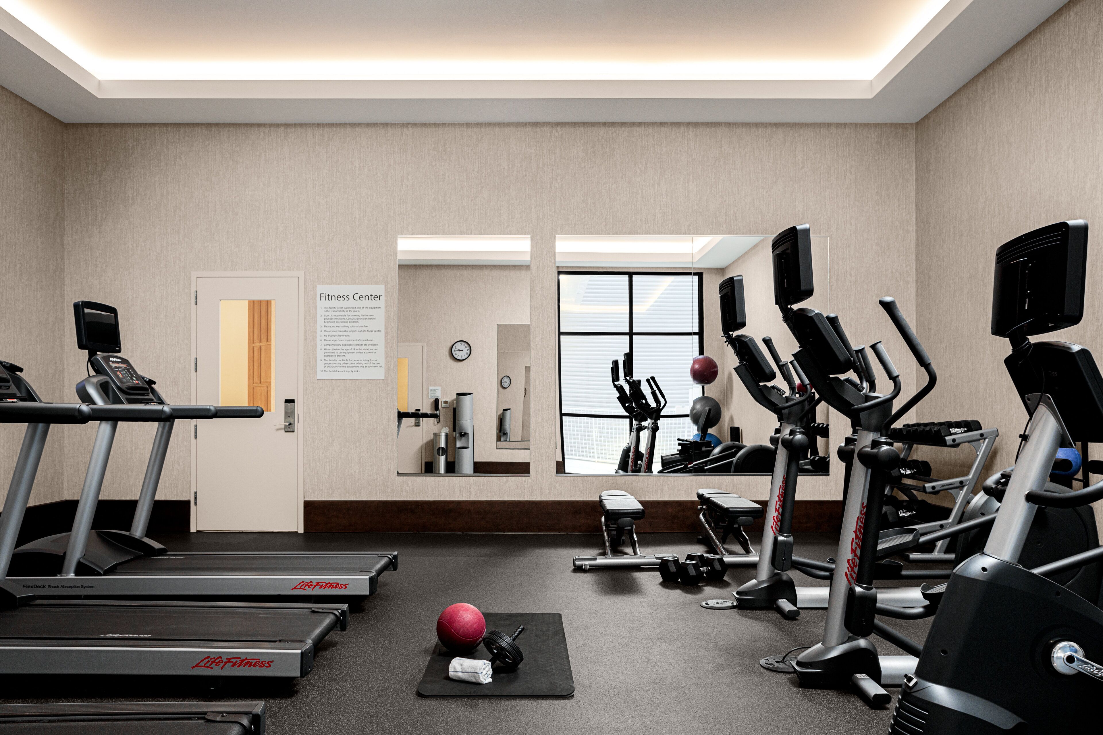 Un centre de remise en forme équipé de tapis de course, de vélos elliptiques et de poids libres.
