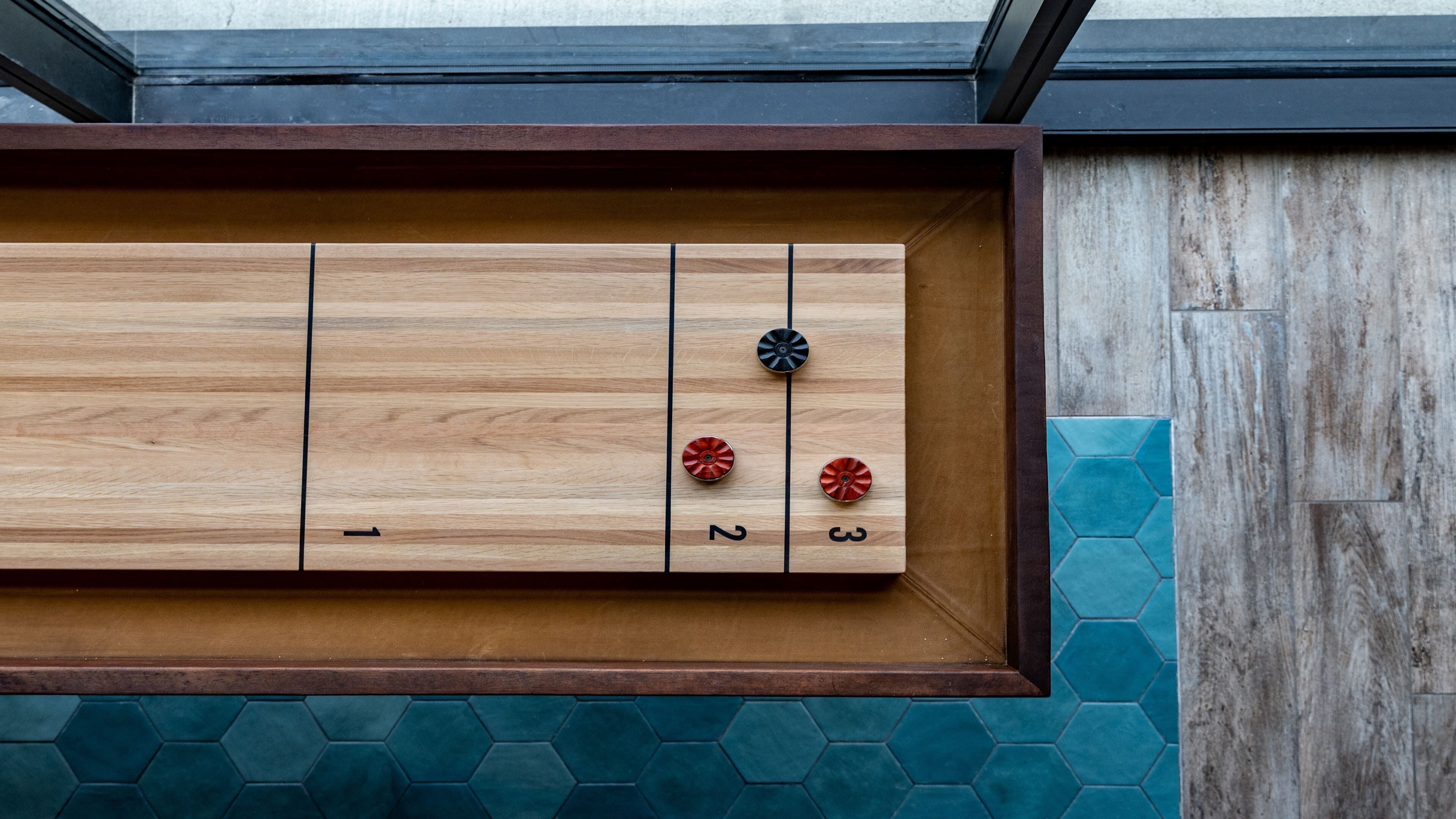 A wooden board game with numbered spaces and two game pieces.