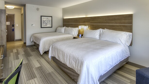 Una habitación de hotel con dos camas, un escritorio y una silla.