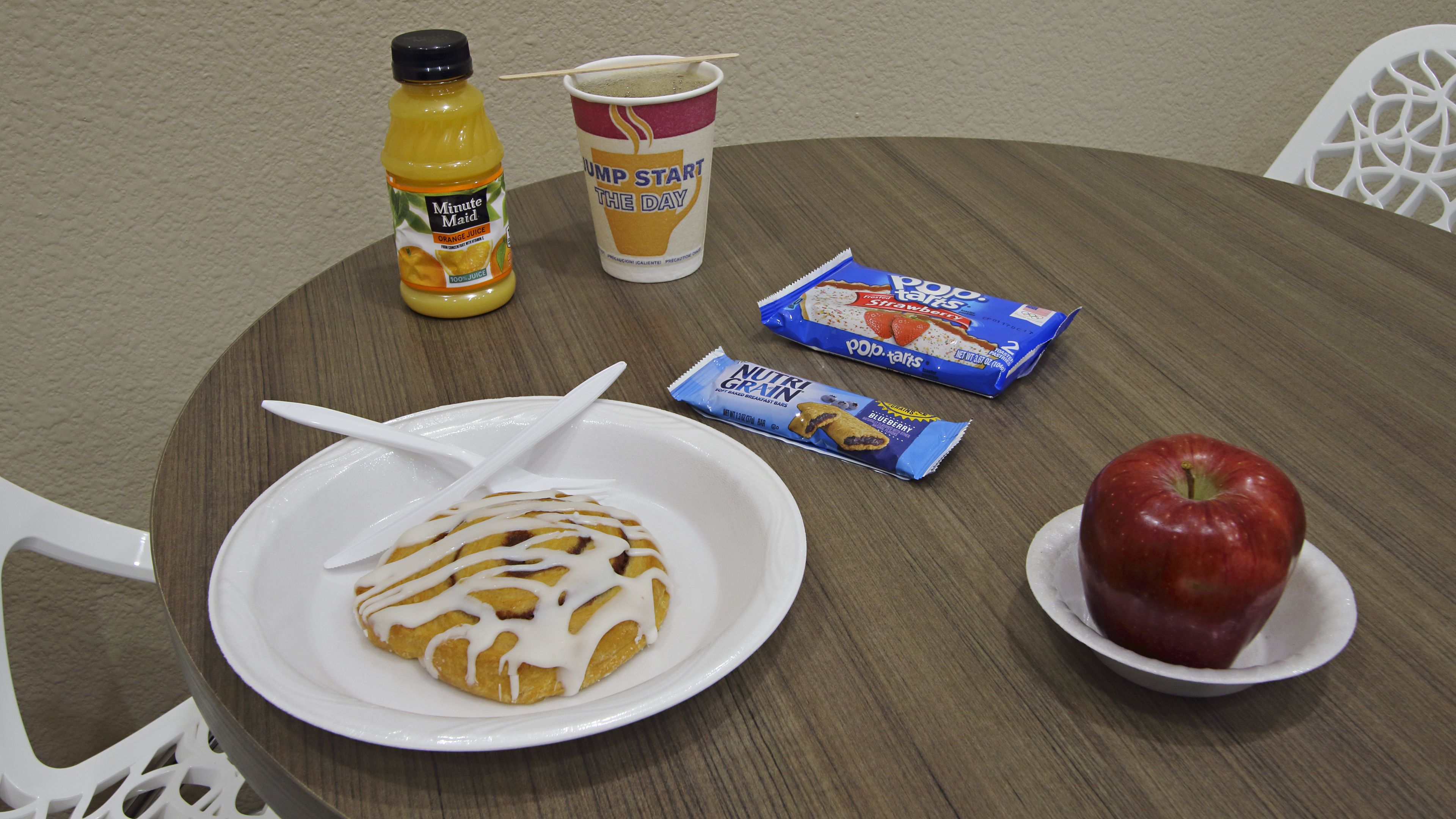 A breakfast setting with a plate of food, a drink, and a snack.