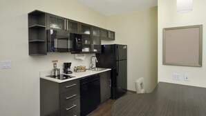 Una cocina compacta equipada con microondas, refrigerador y cafetera.