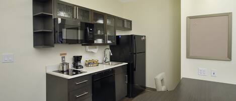 A compact kitchen with a microwave, refrigerator, and coffee maker.