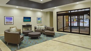 A lobby with a seating area, a reception desk, and a glass door entrance. - Candlewood Suites Dallas-Frisco NW Toyota Ctr by IHG (Frisco)