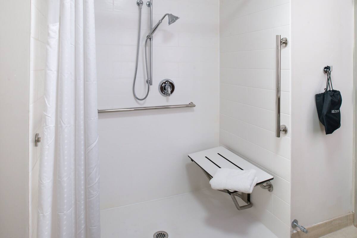 Ein modernes Badezimmer mit Dusche, Handtuchhalter und Toilette.