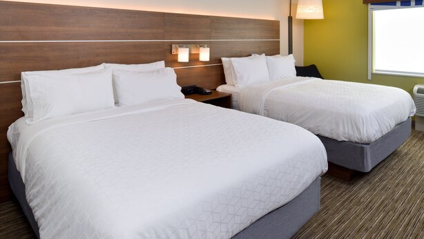 A hotel room with two beds, a nightstand, a lamp, and a window. - Holiday Inn Express & Suites Ottumwa by IHG (Ottumwa)