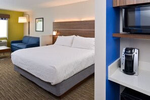 A hotel room with a large bed, a sofa, a coffee machine, and a television on a shelf. - Holiday Inn Express & Suites Ottumwa by IHG (Ottumwa)