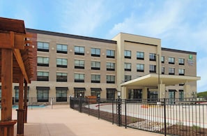 A Holiday Inn Express building with a modern architectural design, featuring a brick facade and a covered entrance. - Holiday Inn Express & Suites Dallas-Frisco NW Toyota Stdm by IHG (Frisco)