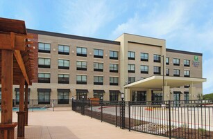 A Holiday Inn Express building with a modern architectural design, featuring a brick facade and a covered entrance.