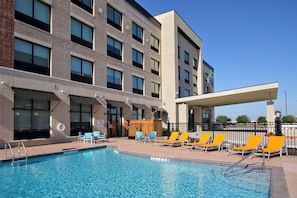 A hotel with a swimming pool, outdoor seating, and a covered area. - Holiday Inn Express & Suites Dallas-Frisco NW Toyota Stdm by IHG (Frisco)