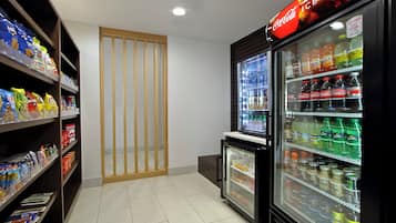 Zona de venta automática con aperitivos y bebidas variadas, incluyendo Coca-Cola y Sprite.