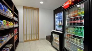 A snack and drink vending area with various snacks and beverages, including Coca-Cola and Sprite.