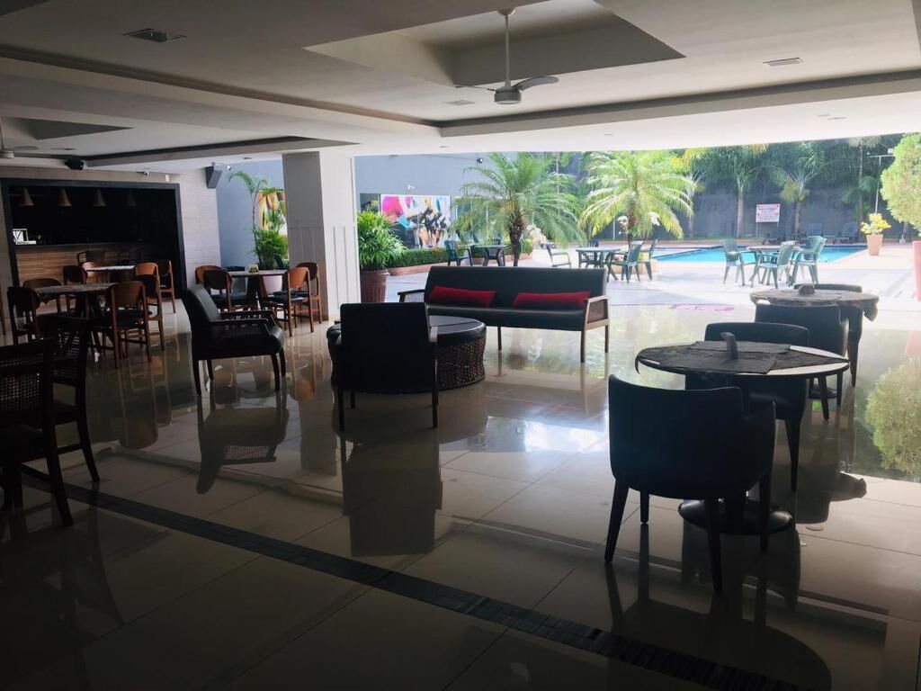 A modern indoor area with a pool view, including seating arrangements and a bar area.