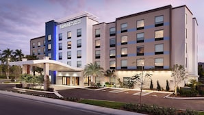 Un hotel Fairfield Inn & Suites by Marriott con un diseño moderno, que cuenta con un acceso cubierto y jardines ajardinados.