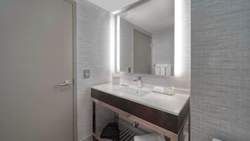 A modern bathroom with a large mirror, a sink, and a toilet.