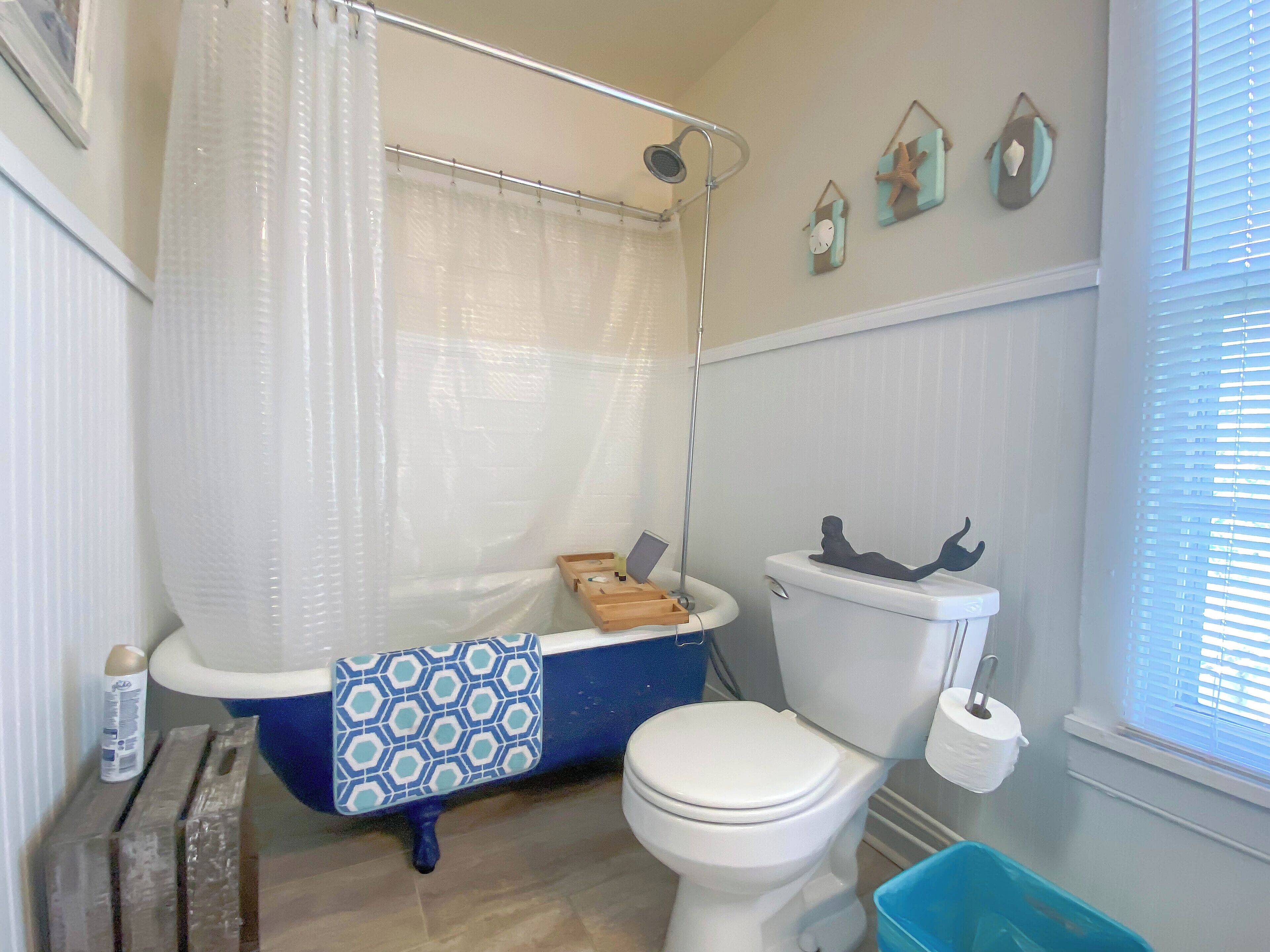 Een badkamer met een bad, toilet en douche.