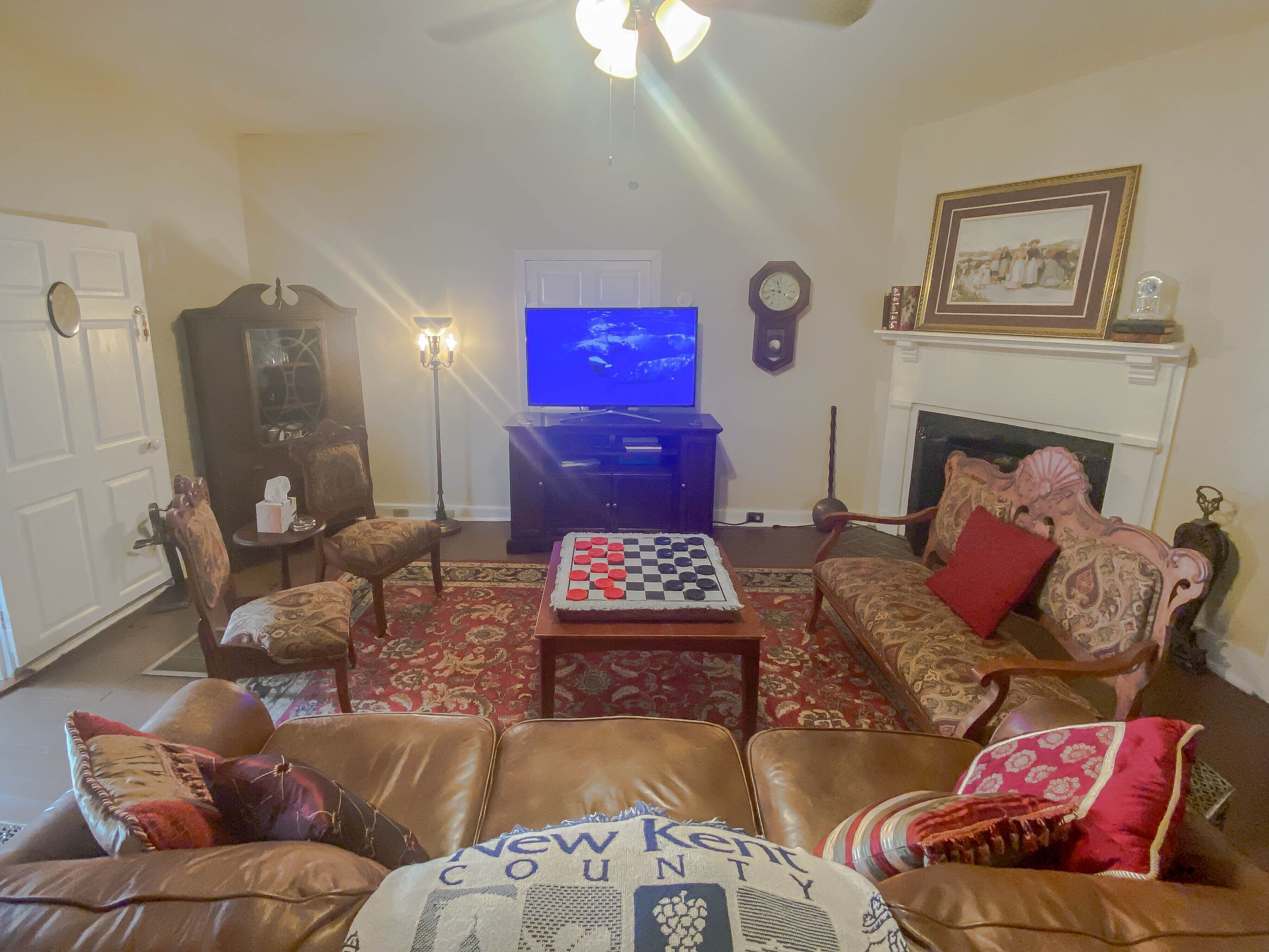 Ein Wohnzimmer mit Kamin, Fernseher und Schachbrett.