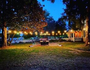 An outdoor patio area with string lights, a small table, and a gazebo. - Vaiden Inn (New Kent)