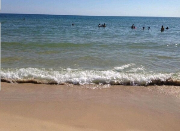 A beach with clear water and a sandy shore.