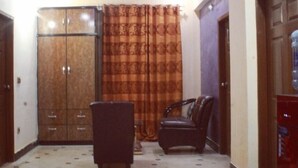 Una habitación con ventilador de techo, sofá, mueble y dispensador de agua.