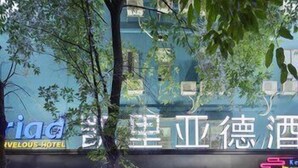 A hotel with a sign in a foreign language, a visible entrance, and a staircase leading to the entrance. - Kyriad Hotel (Guangzhou)