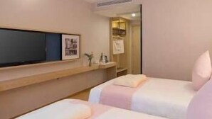 A hotel room with two beds, a flat-screen TV mounted on the wall, and a small shelf with items. - Kyriad Hotel (Guangzhou)