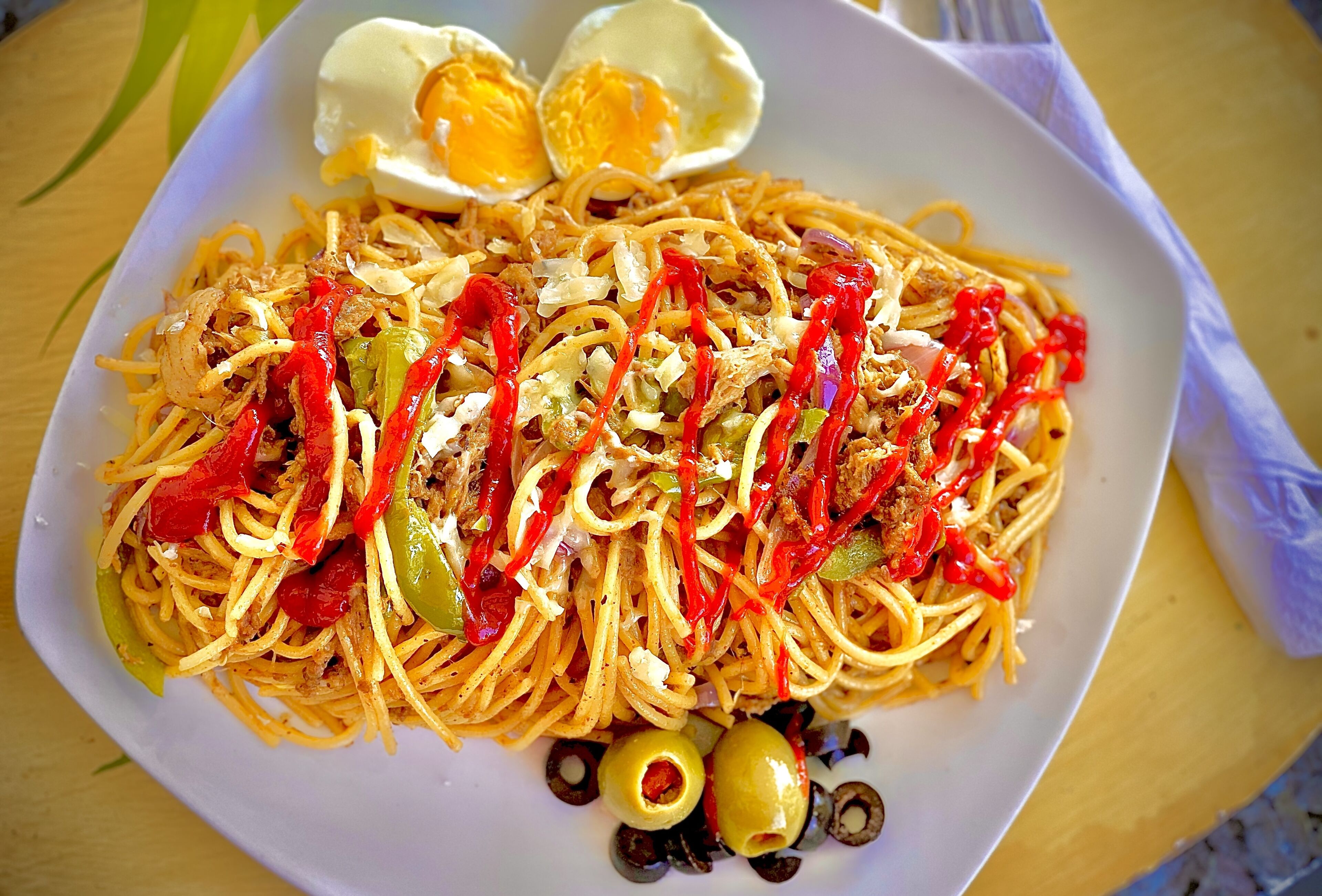 A plate of noodles with vegetables and a boiled egg.