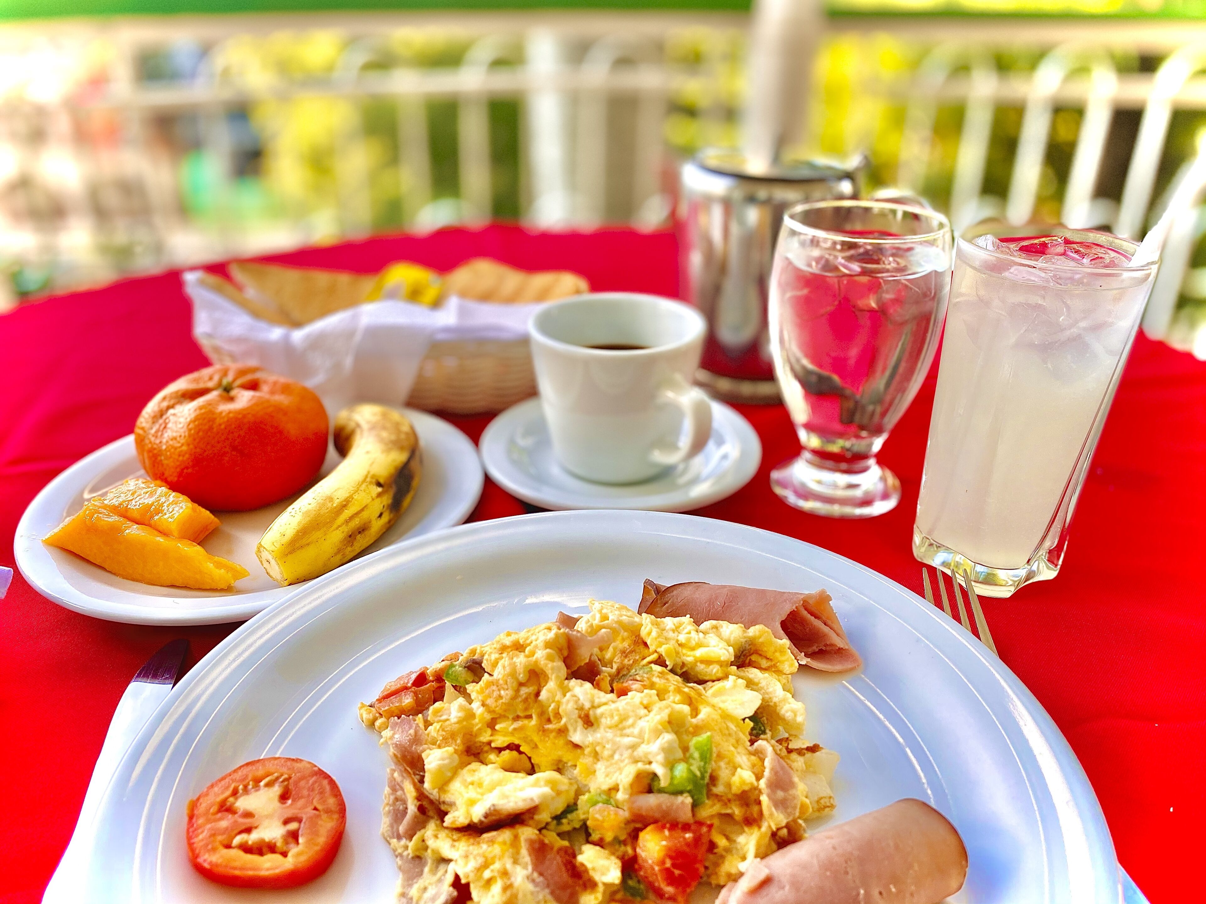 A breakfast table with plates of food, a cup, and glasses.