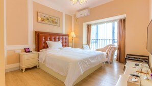 Una habitación de hotel con una cama grande, una silla, un escritorio y una televisión.