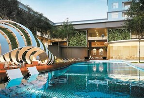 A modern hotel with a swimming pool, lounge area, and a unique architectural design. - Skypod (Puchong)