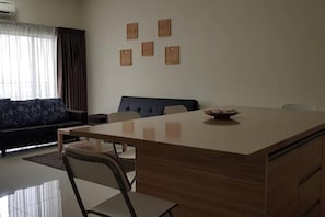 Un espace repas moderne avec un îlot central, un canapé et un luminaire fixé au mur.