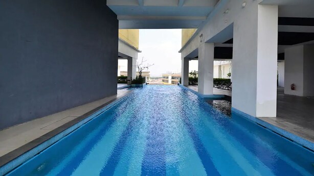 Une piscine offrant une vue dégagée sur le ciel et les bâtiments en arrière-plan.