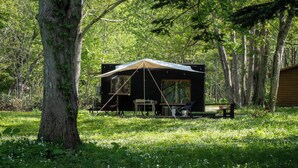Una cabaña apartada con una amplia terraza, rodeada de bosque.