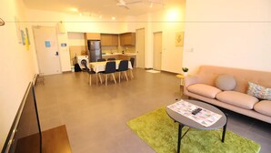 Un salon moderne comprenant un canapé, une table basse et un coin repas avec des chaises et une table.