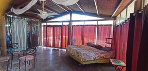 A room with a bed, a table, chairs, and a ceiling fan. - Jungla de Panama (Palmira)