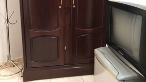 A wardrobe with two doors, a coat rack, and a television on a stand. - Thinh Phuong Nam Hotel (Can Tho)
