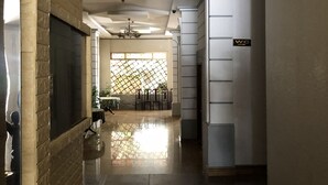 A hallway with a tiled floor, a fireplace, and a 'WC' sign on the wall. - Thinh Phuong Nam Hotel (Can Tho)