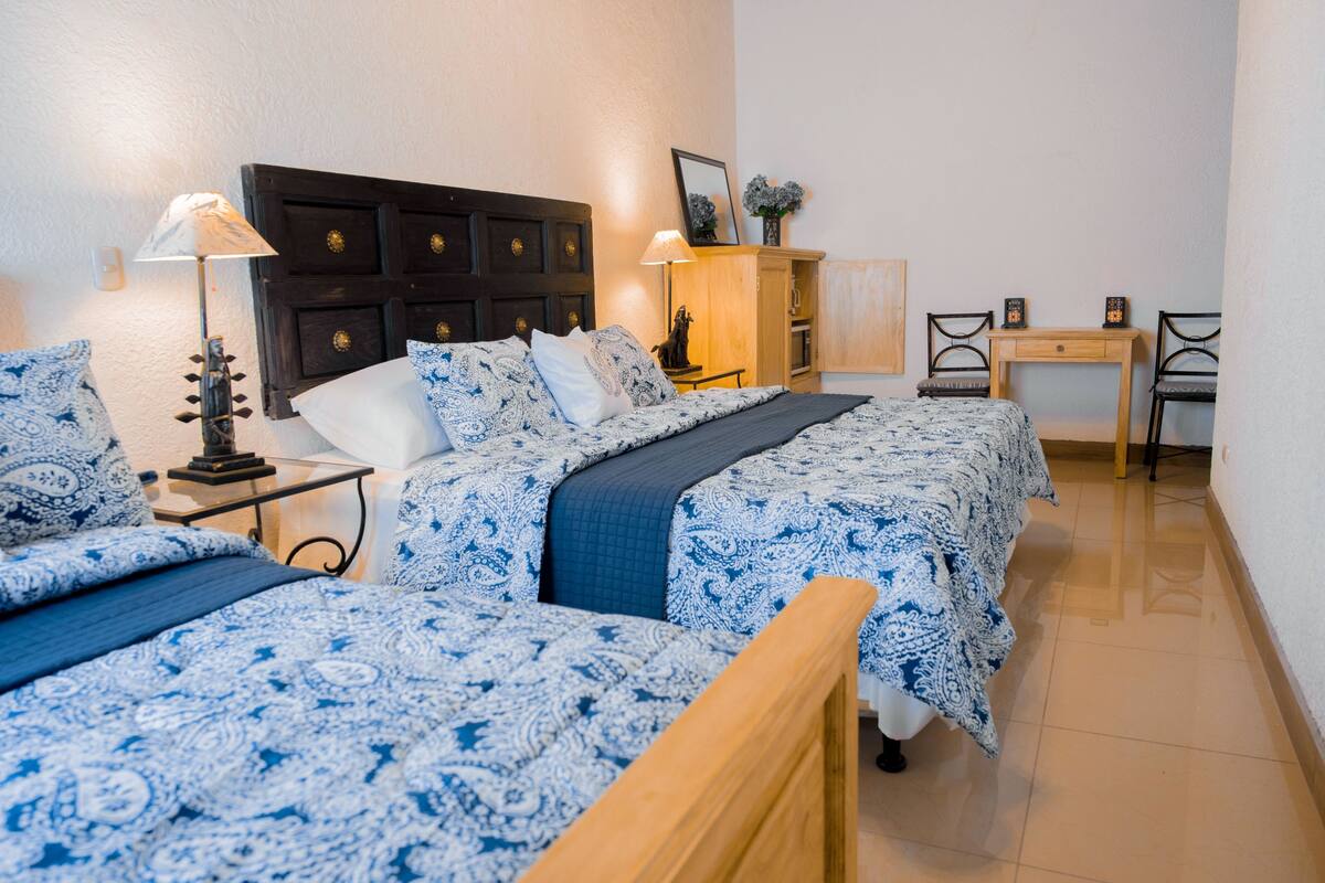 A room with two beds, a desk, and a chair.
