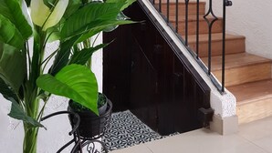Eine Treppe mit schwarzen Metallgeländern und Holzbodenstufen, die zu einer oberen Etage führt.