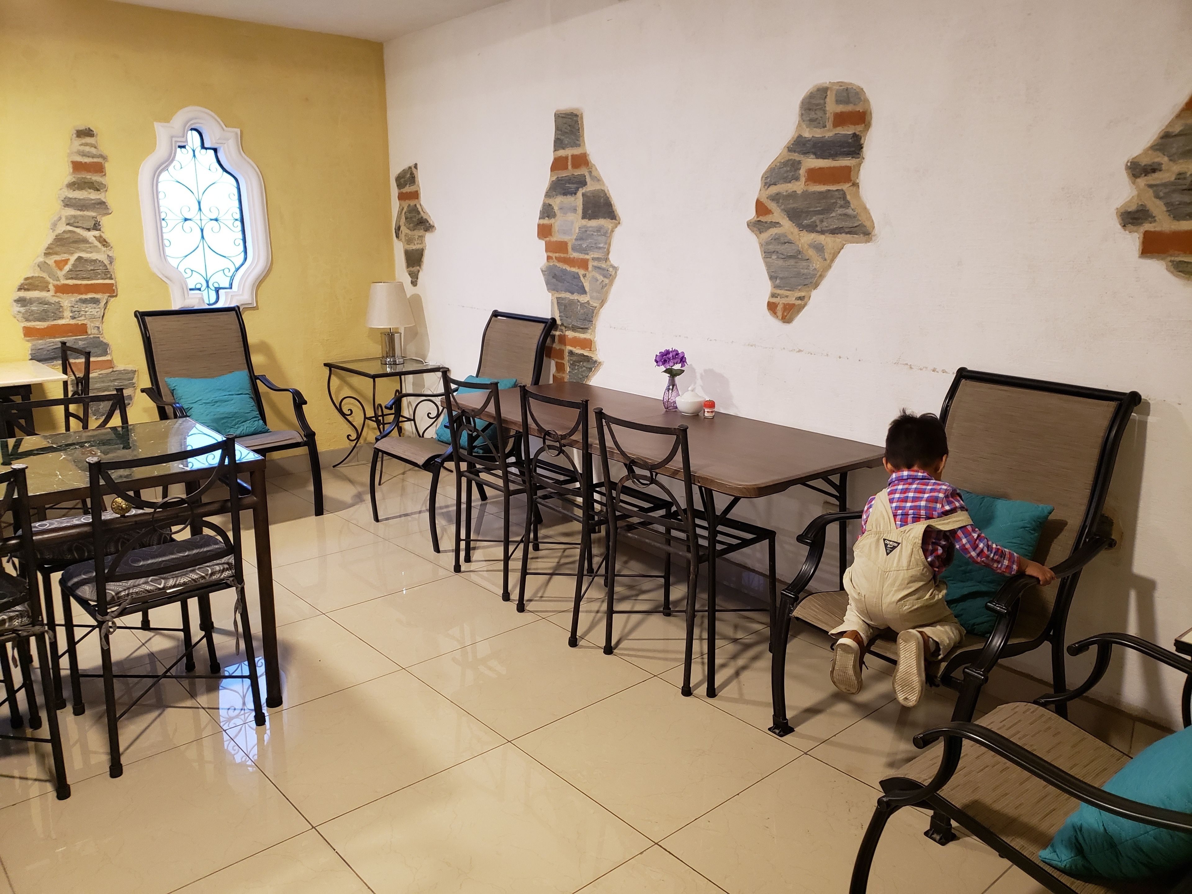 A dining area with a table and chairs, a lamp, and decorative wall art.