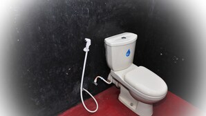 Un inodoro con tanque de agua y manguera.