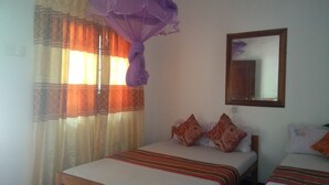 Un dormitorio con dos camas, una ventana con cortinas, un espejo y un enchufe en la pared.