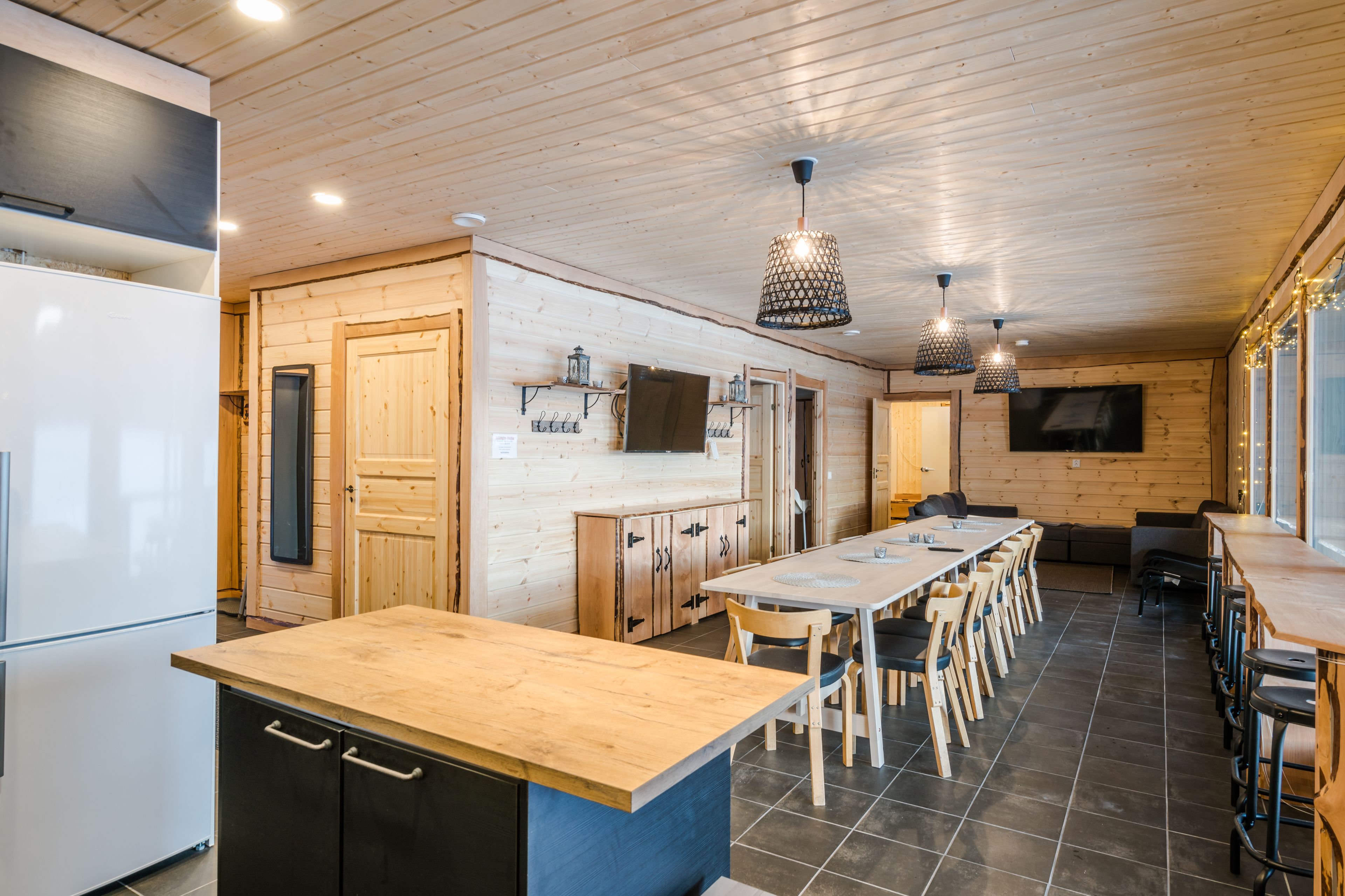 A modern kitchen with wooden cabinets, a large island, and pendant lighting.