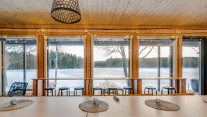 A wooden interior with large windows overlooking a snowy landscape. - Aulanko Lake Villa - Peace & Privacy (Hameenlinna)