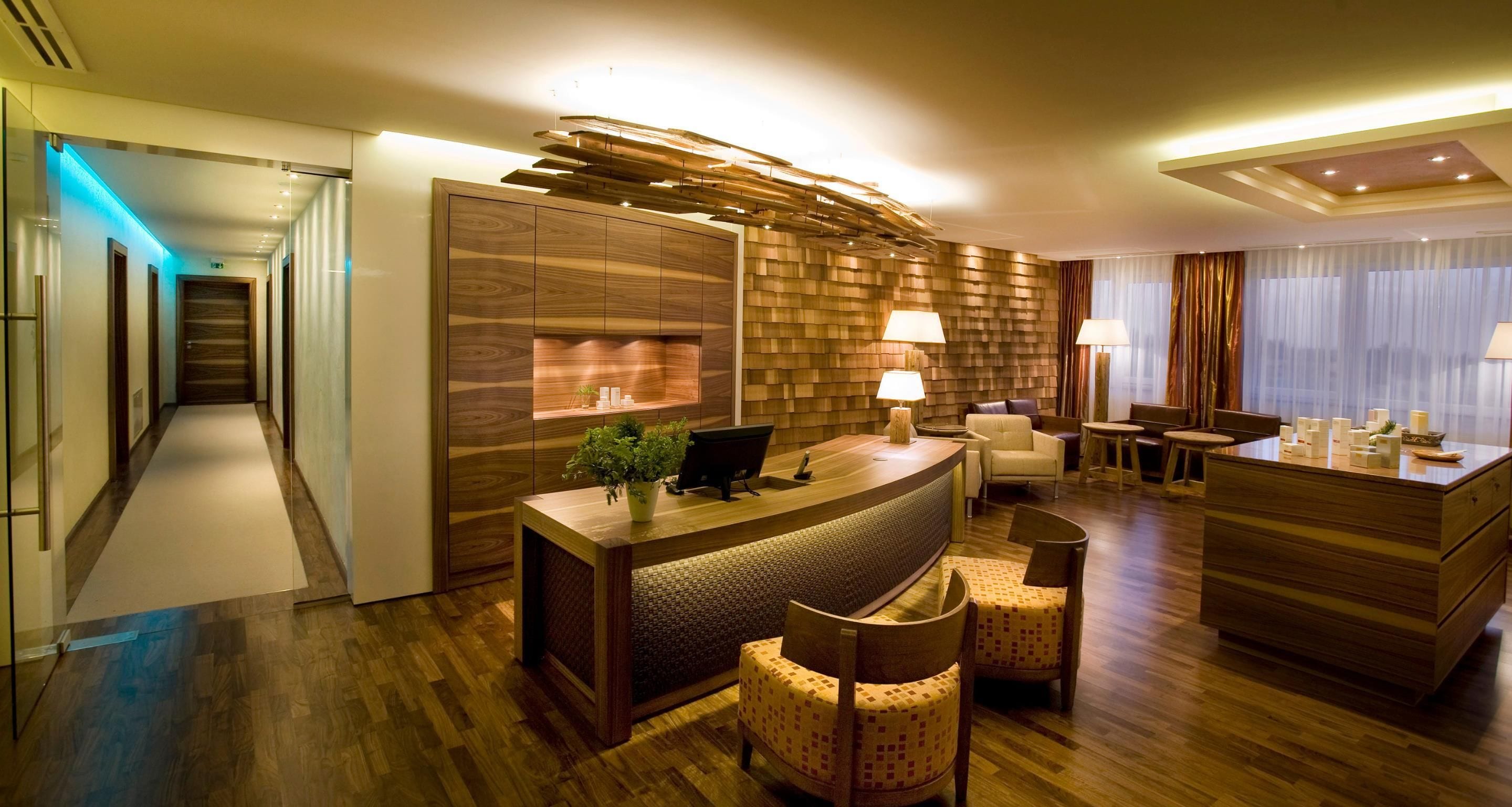 A hotel lobby with a reception desk, seating area, and a modern design.