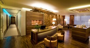 Un vestíbulo de hotel con mostrador de recepción, zona de estar y diseño moderno.
