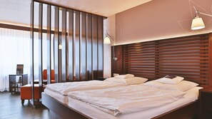Habitación de hotel con dos camas, un escritorio y una silla.