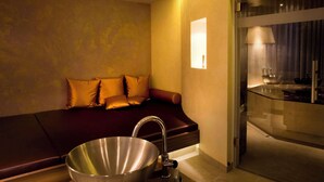 Un baño moderno con un espejo grande, un lavamanos y una zona de ducha.