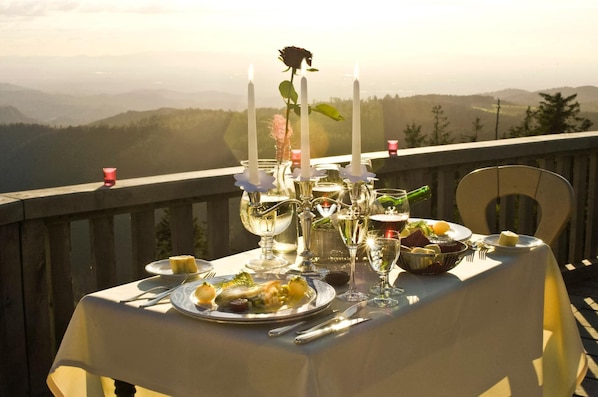 Una mesa preparada para una comida con una vista panorámica de montañas al fondo.