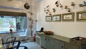 A dining area with a table and chairs, a potted plant, and a cabinet with drawers. - LanJen Villa B&B (Tainan)